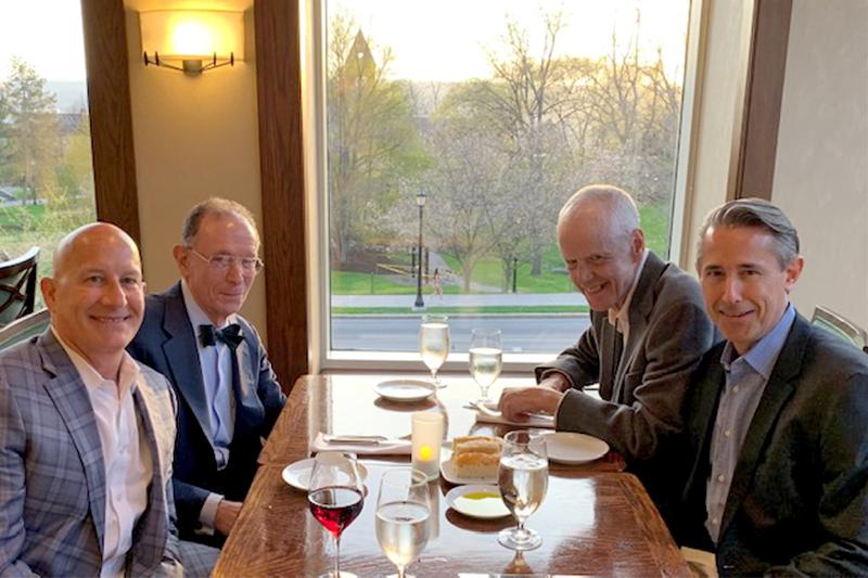 Professor Michael Gold sitting at a dining table with former MILR students.