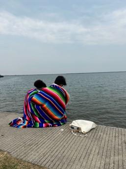 chinaza and owen sit near the water