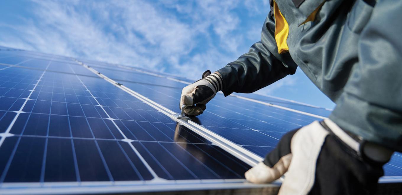 close up view of two hands installing a solar panel