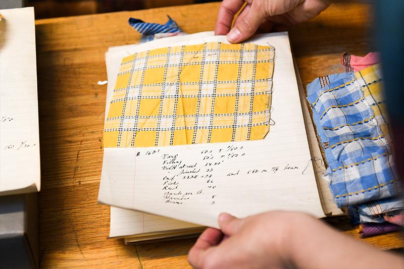 older fabric swatch saved in a book with handwritten notations