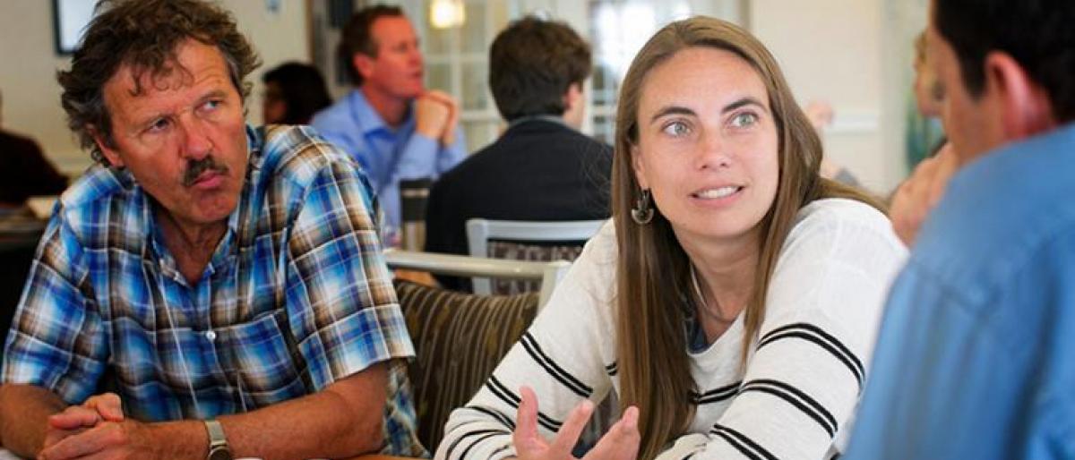 Image of Lara Skinner sitting around table with others