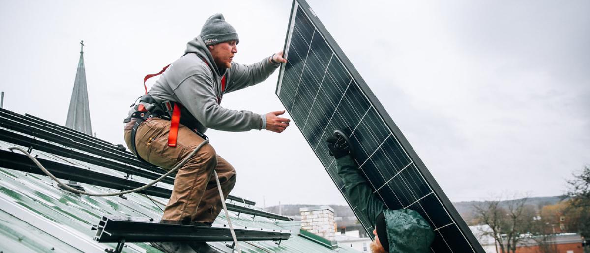 Two workers installing solar panels