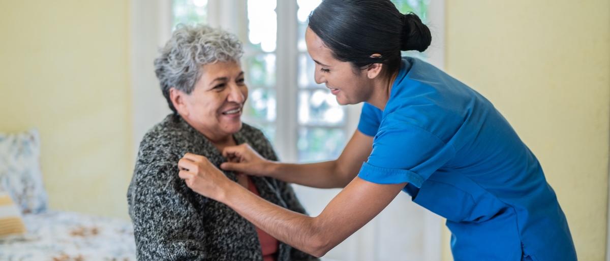 caregiver assisting in a bedroom