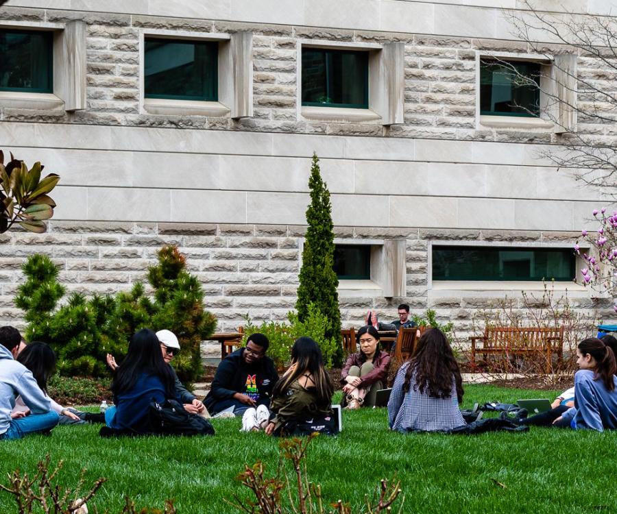 undergraduate students sitting on the grass in ILR's lower courtyard