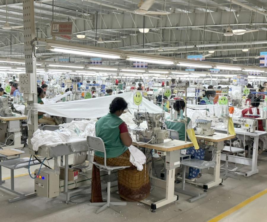 Busy factory floor with rows of sewing stations