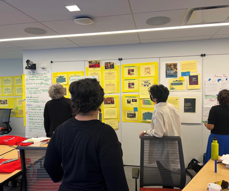 Training participants viewing posters detailing important court cases and social movement efforts to advance equity.