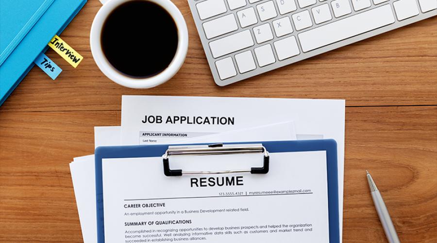 resume and job application forms on a desk with a cup of coffee