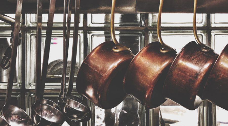 Copper pots hanging in restaurant kitchen