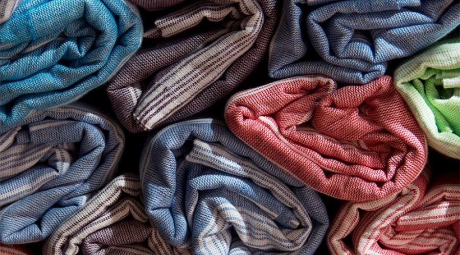 Bolts of colorful fabric rolled and piled together