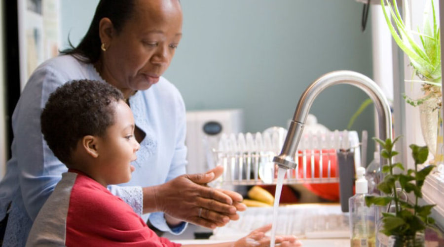 Woman washing hands with child