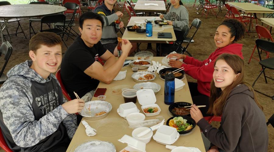 Policy debaters eat lunch outside during a tournament break