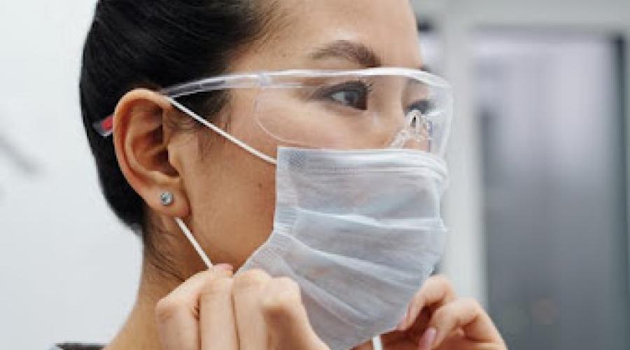 Healthcare worker puts on a mask