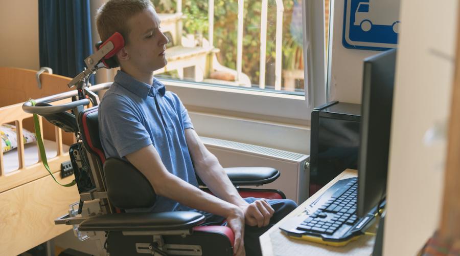 young person with a disability uses computer technology to create an absentee ballot at home