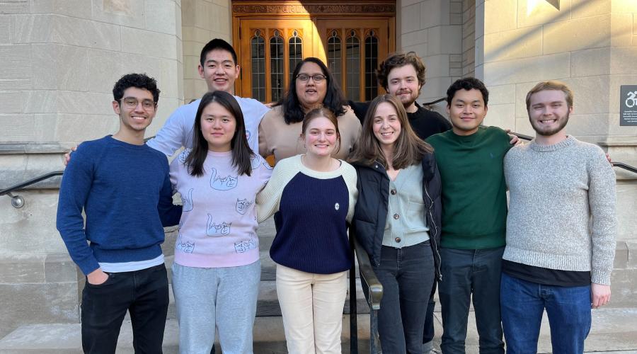 8 students stand on the steps before a tournament
