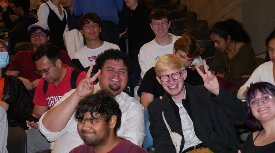 A group of sitting students smile