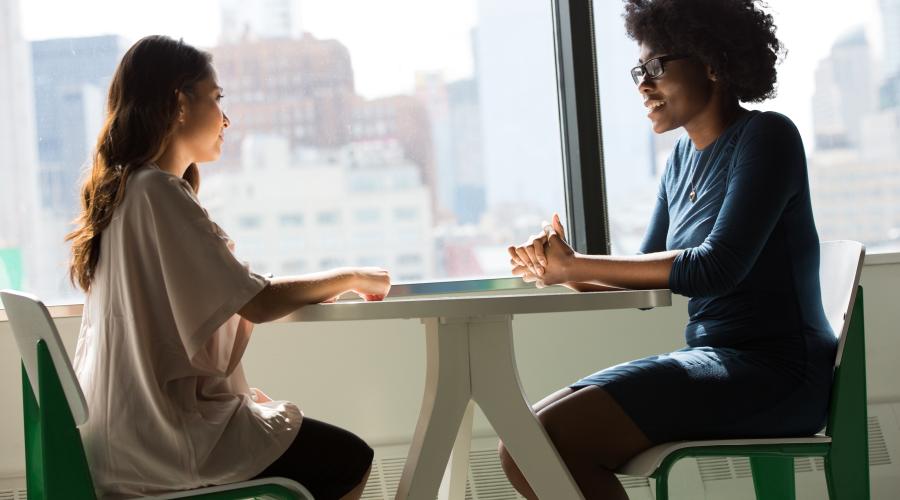 two people sitting at a table in a job interview