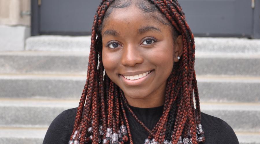Nshera smiles in front of stairs