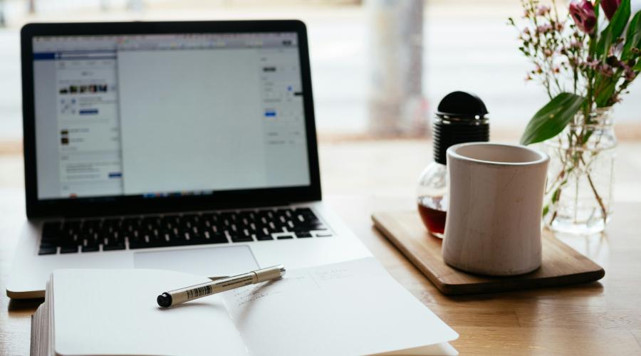 laptop and open notebook on a desk