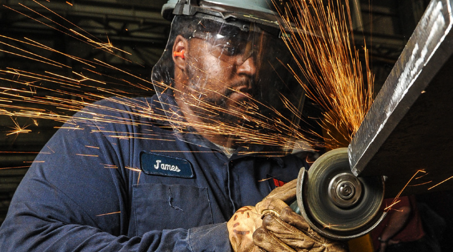 A worker sawing metal