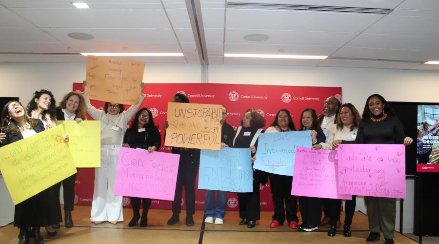 Group of people on stage holding up signs