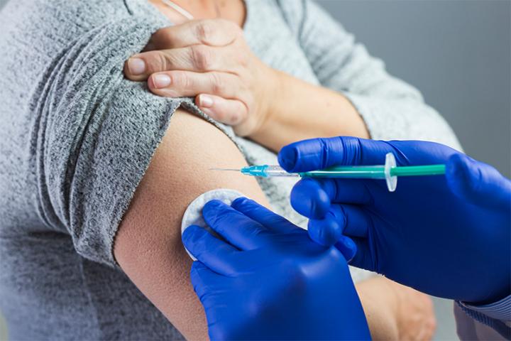 woman receiving a vaccination shot in the upper arm