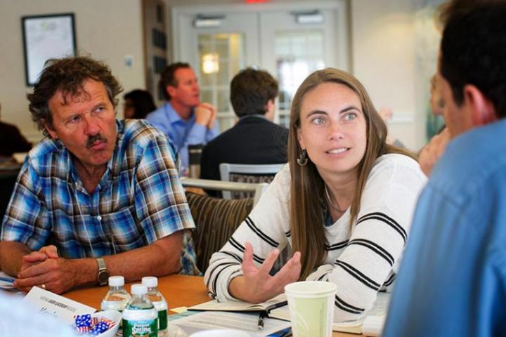 Image of Lara Skinner sitting around table with others