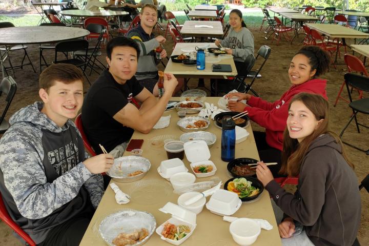 Policy debaters eat lunch outside during a tournament break