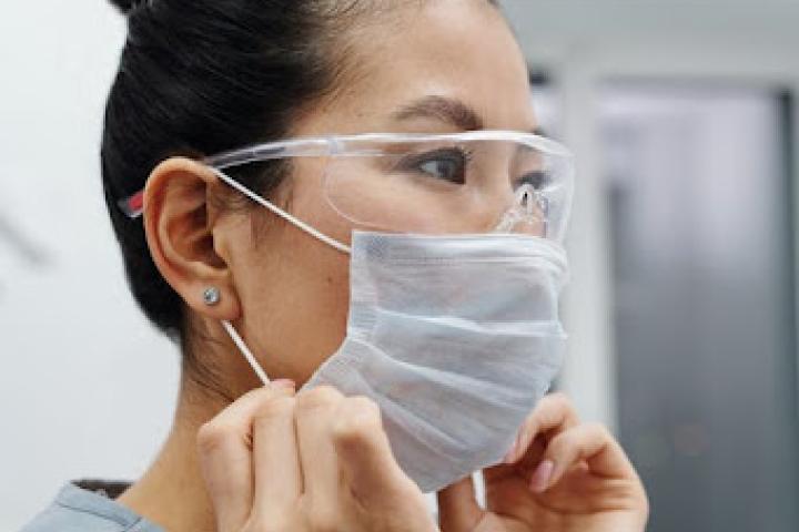 Healthcare worker puts on a mask