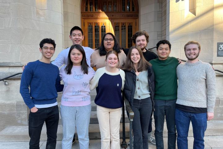 8 students stand on the steps before a tournament