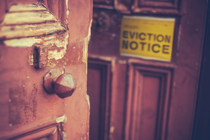 An eviction notice hangs on a door.