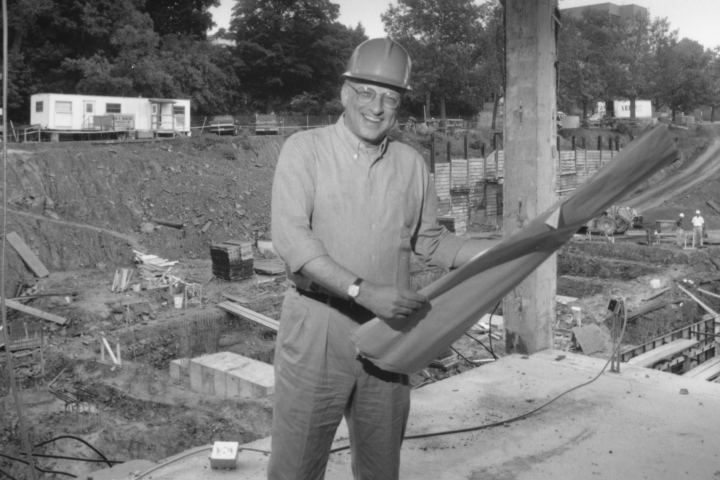 Dave Lipsky holding architecture plans at a building site
