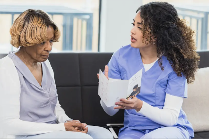 Nurse and patient converse in hospital setting