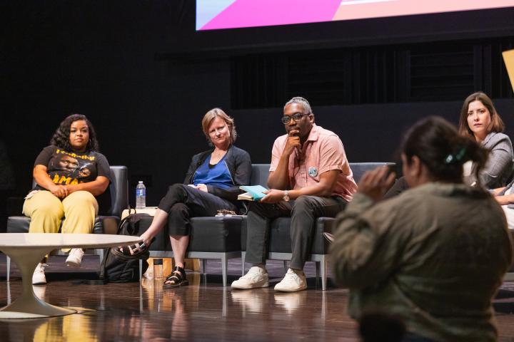 panelists listen to audience member asking question
