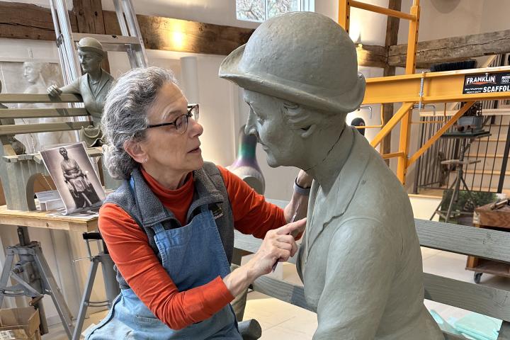 A sculptor works on an image of Francis Perkins