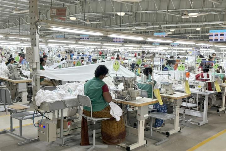 Busy factory floor with rows of sewing stations