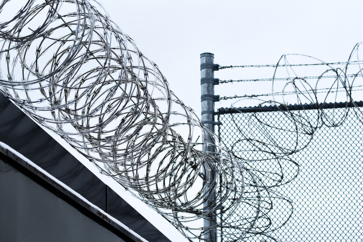 Barbed wire at the top of a prison wall 
