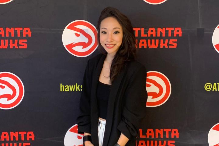 Jennifer Choi ’08 standing in front of an Atlanta Hawks step and repeat. 