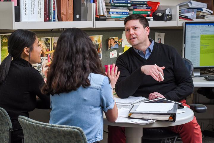 Adam Seth Litwin speaks with two undergraduates in his office in Ives Hall. 