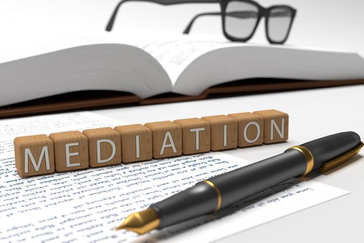 Alphabet blocks spell out the word Mediation on a desk. 