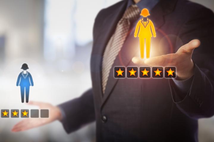 Unrecognizable manager is evaluating a female employee icon with a five star rating versus one with three.
