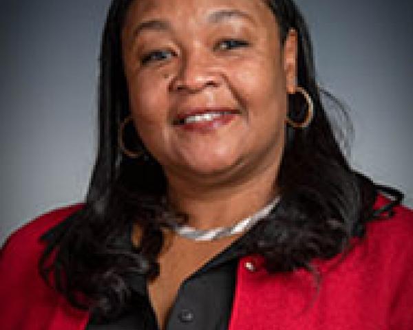 woman with red jacket smiles at camera