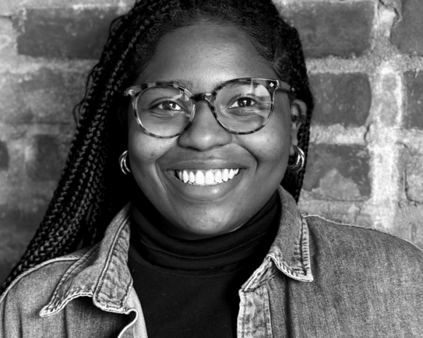 woman in glasses smiles at camera