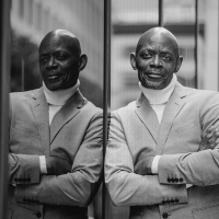 Man leaning reflected against city glass door