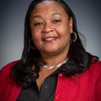 woman with red jacket smiles at camera